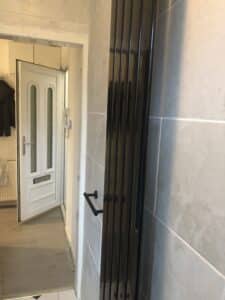 black upright vertical radiator and towel rail installation in Bellahouston