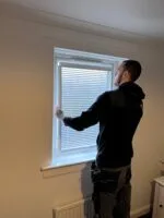 Handyman installing EasyFit blind on window frame